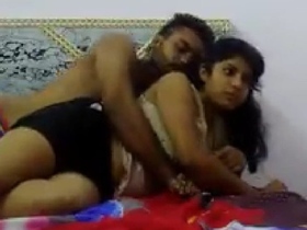 A youthful pair engages in intimate activities on the bed