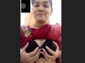 A stunning woman flaunts her large breasts and alluring pussy in a teasing display on camera