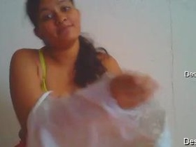 A lovely woman with natural breasts dresses in front of the camera