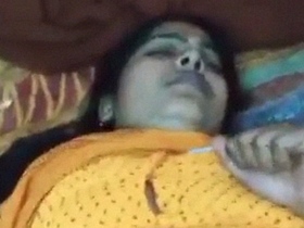 Watch a mature auntie in yellow sari in a steamy video