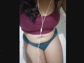 A seductive Indian woman with large breasts indulges in playful activities