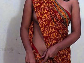 Slim middle-aged woman in a sari without a bra reveals her alluring bosom and belly button