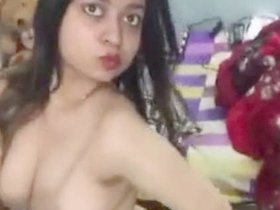 A young Indian woman reveals her large breasts and unshaven vagina