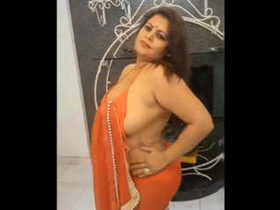 Sapna Bhabhi shows off her ample bosom and uncovers her orange sari